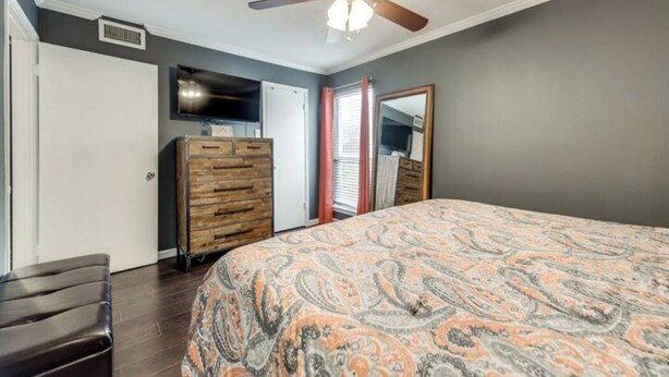 A bedroom with a bed, dresser, ceiling fan, and a television. - I40 - Apt|Patio|11mi to Convention Ctr|Sleeps 2 (Irving)