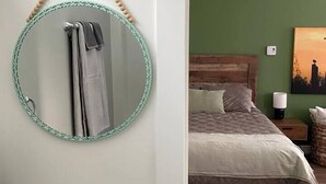 A bedroom with a bed, a round mirror, a sink, and a ceiling fan. - Birch Suite Hillside (Golden)