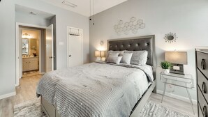 Una camera da letto con un letto, comodini, una ventola a soffitto e un punto luce a parete.