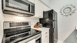 A kitchen with a microwave, oven, and refrigerator.