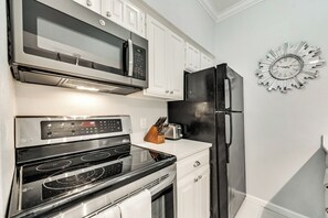 A kitchen with a microwave, oven, and refrigerator. - I46 - Apt|Patio|11mi to Convention Ctr|Sleeps 2 (Irving)