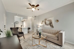 A modern living room with a sofa, coffee table, and a ceiling fan.