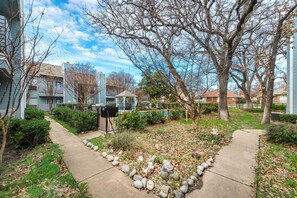 A residential area with a pathway, a gazebo, and a swimming pool.