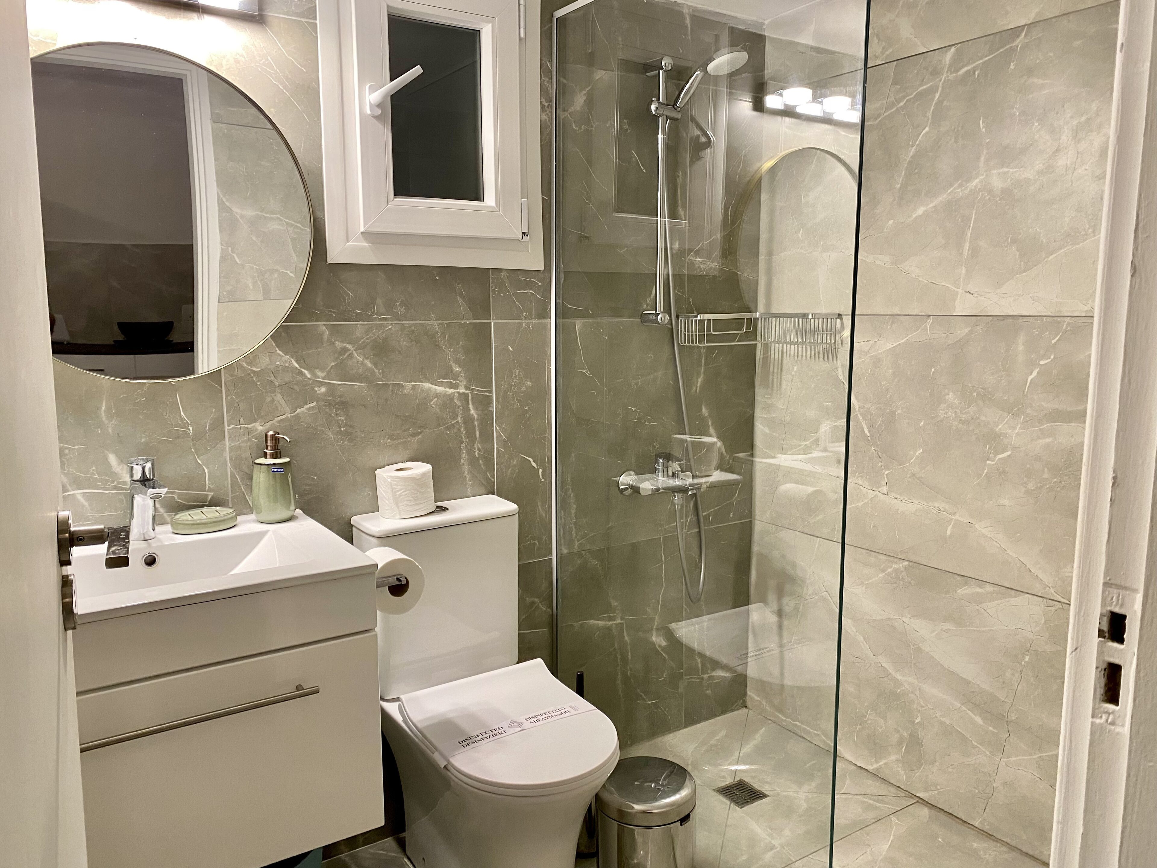 A modern bathroom with a toilet, sink, and shower.