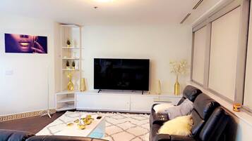 Appart'hÎtel Luxe | Coin séjour | TV connectée de 75 pouces avec chaßnes numériques, cheminée, Netflix