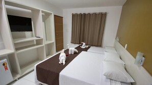 A hotel room with two beds, a TV, a wardrobe, and a small fridge. - Pousada Maragolfinho (Maragogi)
