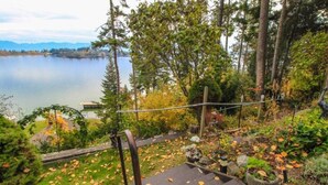 A view of a lake with a wooden staircase leading down to a dock, surrounded by trees and autumn leaves. - Somers Lookout on Flathead Lake, private dock (Somers)