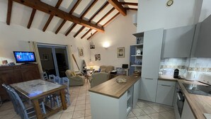 Amplia sala de estar con cocina, mesa de comedor y asientos.