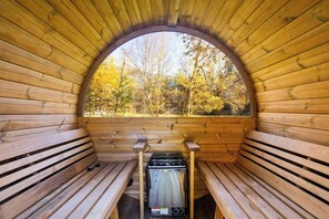 A wooden sauna with benches and a view of autumn trees. - Cozy Abode w/ Sauna & Views (Columbia Falls)