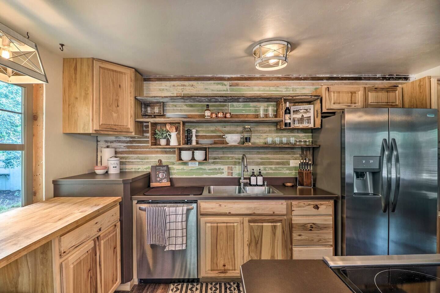 A modern kitchen with wooden cabinets, a stainless steel refrigerator, and a built-in sink.
