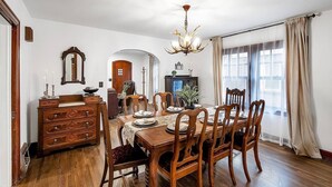 A dining room with a wooden table, chairs, a chandelier, and a mirror on the wall. - Riverside Renaissance - Spa!  King Beds! Beautiful Renaissance decor (Wichita)