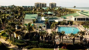 Un resort con piscina, palmeras y vistas a la playa.