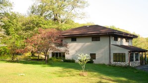 Une maison à deux étages dotée d’un porche abrité, de fondations en pierre et d’une pelouse bien entretenue.
