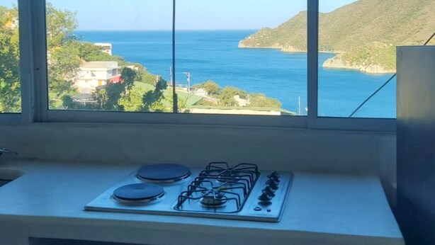 Una cucina con gas e una finestra vista mare.