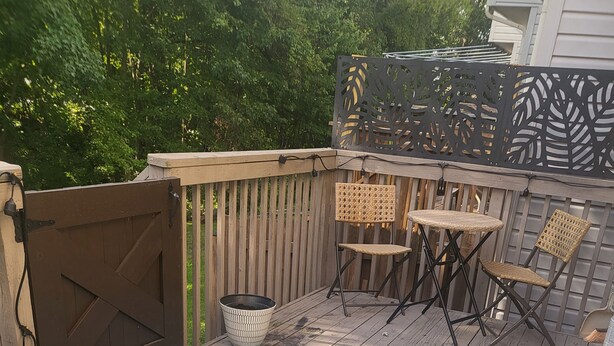 A wooden deck with a blue rug, wicker chairs, and a decorative fence. - Near University of Delaware, Christiana Care Hospital, & the Christiana Mall! (Newark)