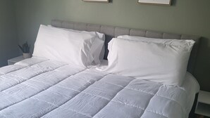 A neatly made bed with white bedding, a grey headboard, and two framed botanical prints on the wall. - Near University of Delaware, Christiana Care Hospital, & the Christiana Mall! (Newark)