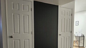 A room with a wooden floor, white doors, and a black sliding door. - Near University of Delaware, Christiana Care Hospital, & the Christiana Mall! (Newark)