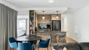 Una cocina moderna con armarios de madera, un refrigerador de acero inoxidable e iluminación colgante.