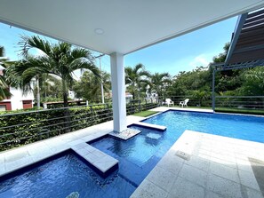 A swimming pool with steps leading into it, surrounded by greenery and palm trees. - Fantástica Casa Finca piscina privada (Ricaurte)