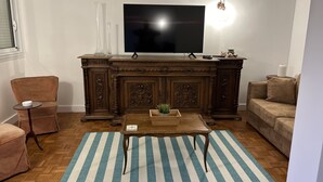 Un soggiorno con un mobile in legno, un televisore, un tavolino da caffè e due divani.