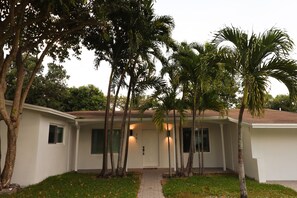 A single-story house with a white exterior, a front door, and a small porch area. - Villa Cristina in Miami (Miami)