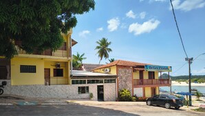 A two-story building with a yellow facade and a sign for 'Bellas Praias'.