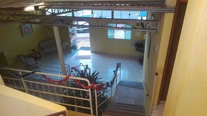 A staircase leading to a lower level with a view of the interior space, including a seating area and a window with a view of the outside.