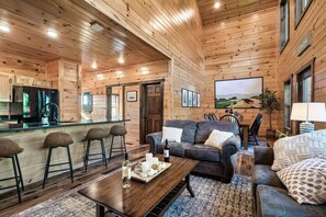 Un intérieur en bois comprenant une cuisine, un coin bar et un espace salon.