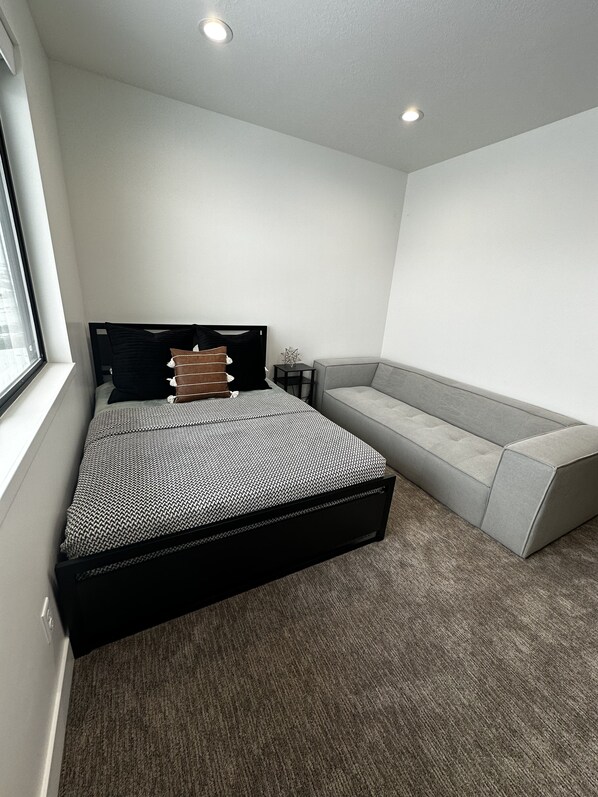 A bedroom with a bed, a bench, and a small table.