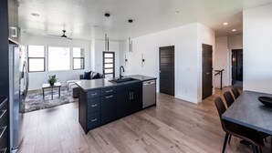 Une cuisine moderne dotée d’un îlot central, d’appareils électroménagers intégrés et d’un coin repas avec une table et des chaises.