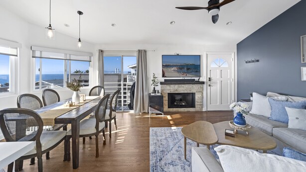 A spacious living room with a dining area, a fireplace, and a view of the sea. - Top Floor Unit with Panoramic Views Steps to the beach with 3 Parking Spots!  (Manhattan Beach)