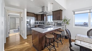A modern kitchen with a large island, stainless steel appliances, and a view to the outside. - Top Floor Unit with Panoramic Views Steps to the beach with 3 Parking Spots!  (Manhattan Beach)