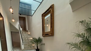 A hallway with marble flooring, a staircase, a large mirror, and potted plants. - Riad Jbara 2 (Rabat)