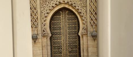 A framed architectural detail with an ornate arch and a patterned door.