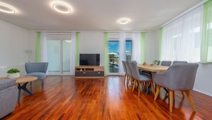 A modern living room with a TV, seating, and a dining area. - Lovely home in Debelo Brdo with sauna (Debelo Brdo)