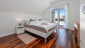 A bedroom with a bed, nightstand, and a view through a glass door. - Lovely home in Debelo Brdo with sauna (Debelo Brdo)