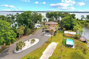 Una propiedad residencial con un camino de entrada curvo, una piscina y vistas a un lago.