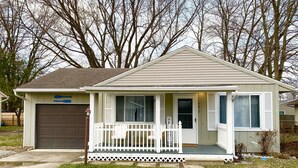 A small single-story house with a front porch, a garage, and a mailbox. - Oasis on Empire near Buckeye Lake! (Thornville)
