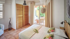 Een slaapkamer met een bed, een houten garderobe, een klein girafdecoratie en uitzicht op buiten.
