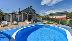 A swimming pool with lounge chairs and a covered patio area. - Stunning home in Sveti Kriz (Sveti Kriz)