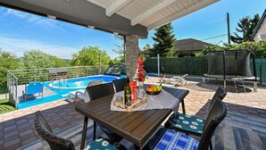 A covered patio with a pool, outdoor furniture, and a table set for dining. - Stunning home in Sveti Kriz (Sveti Kriz)