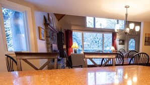 Una cocina con encimeras de granito, armarios de madera y un comedor con sillas y una mesa.