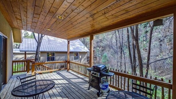 A covered deck with a grill and outdoor seating. - Find your Paradise 1, right in the middle of what brings you to Ruidoso! (Ruidoso)
