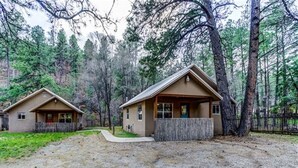 Two cabins in a forested area with a gravel driveway and wooden fences. - Find your Paradise 1, right in the middle of what brings you to Ruidoso! (Ruidoso)