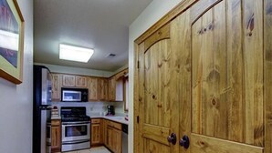 A kitchen with wooden cabinets, a microwave, stove, and a dishwasher. - Find your Paradise 1, right in the middle of what brings you to Ruidoso! (Ruidoso)