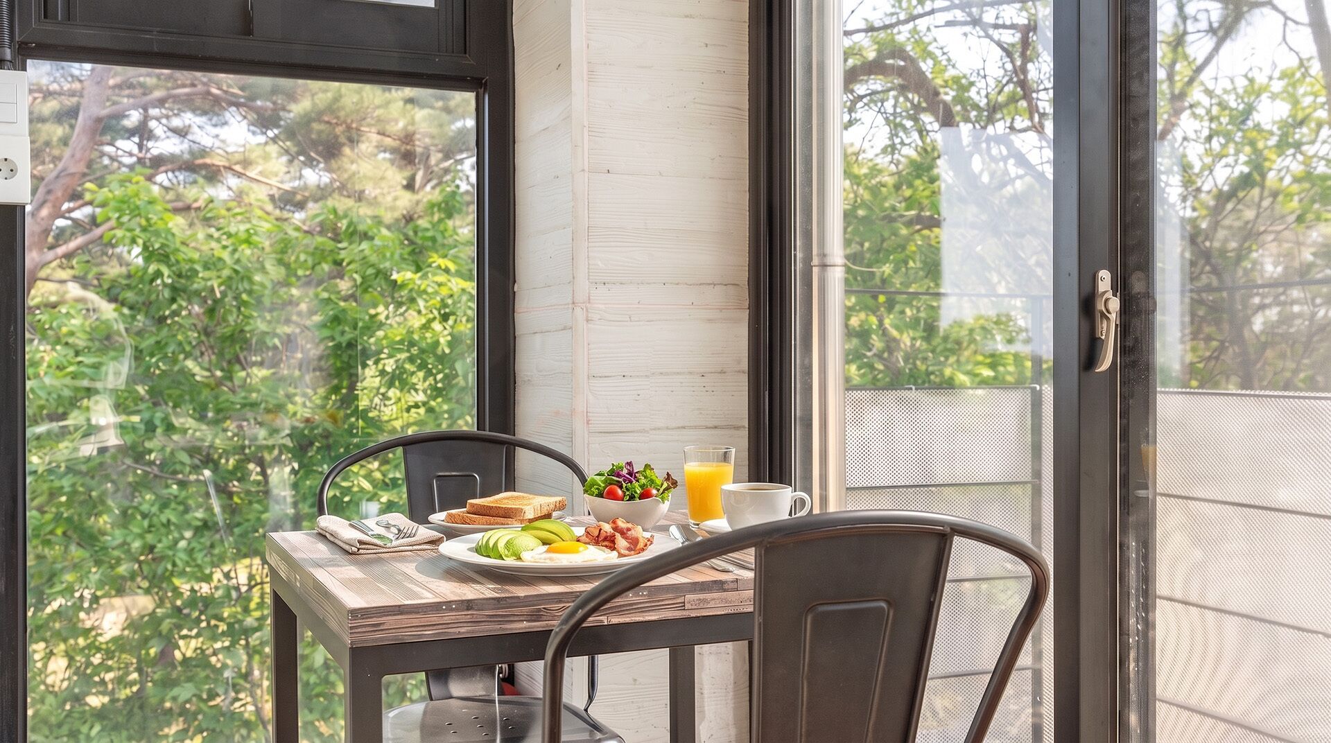 A dining table with breakfast items, a chair, and a view of trees through a window.