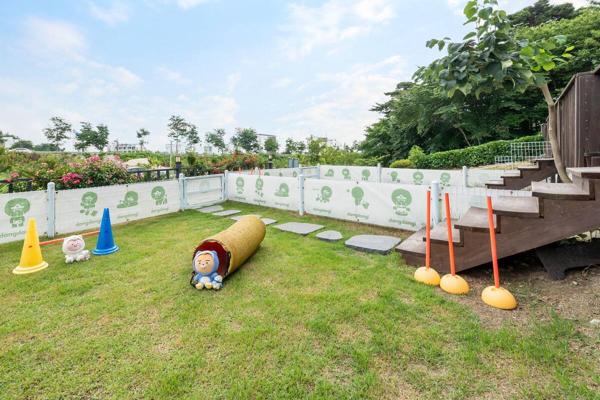 A playground with a slide, a tunnel, and various play structures.