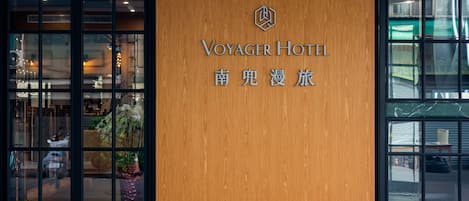 The exterior of the Voyager Hotel with a wooden facade and large windows.