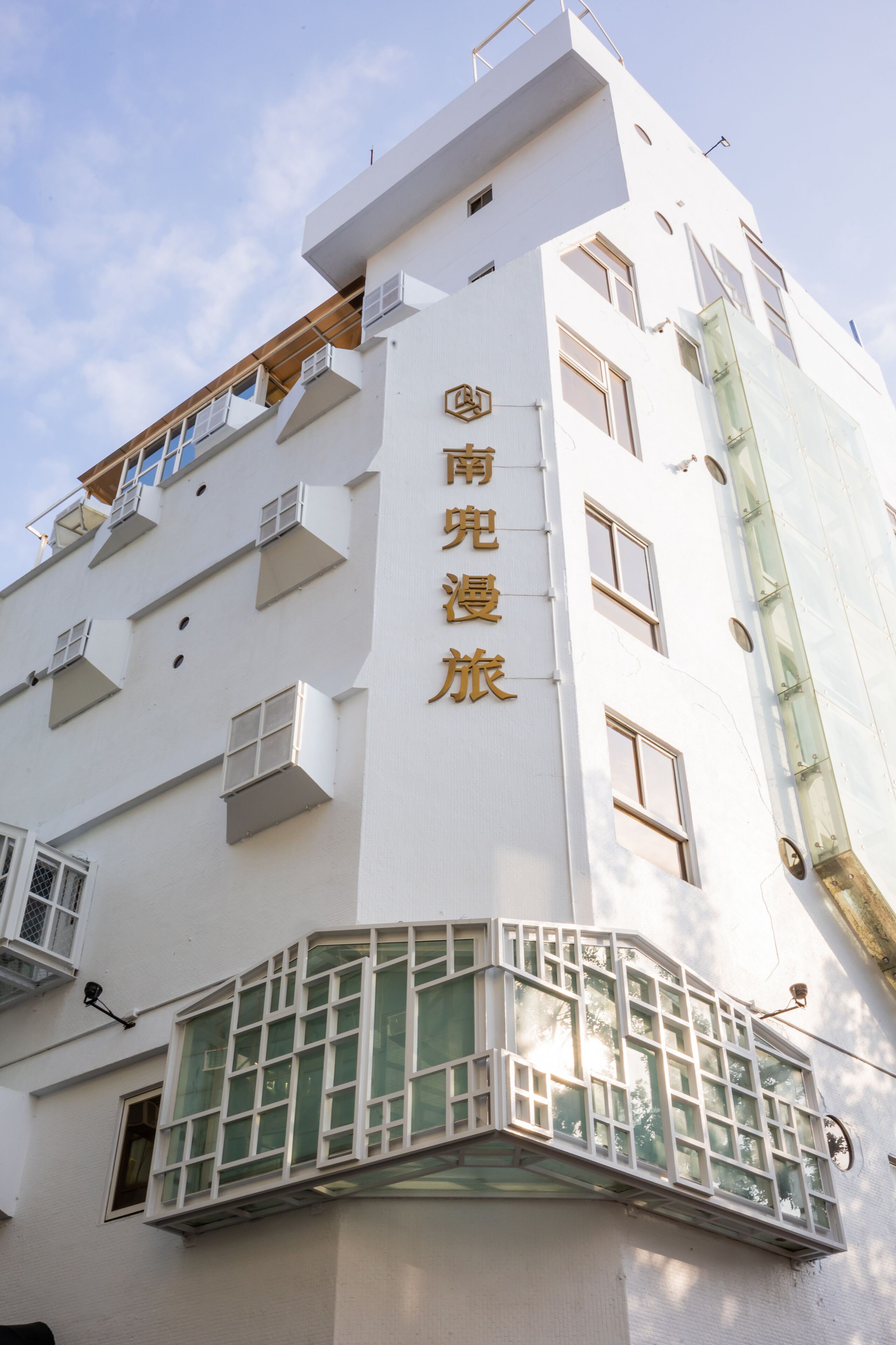 A white building with a sign reading "南海旅馆" (South Sea Hotel).