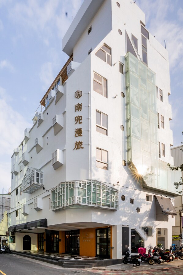 A multi-story hotel with a modern design, featuring balconies and a glass facade. - Voyager Hotel (Tainan)